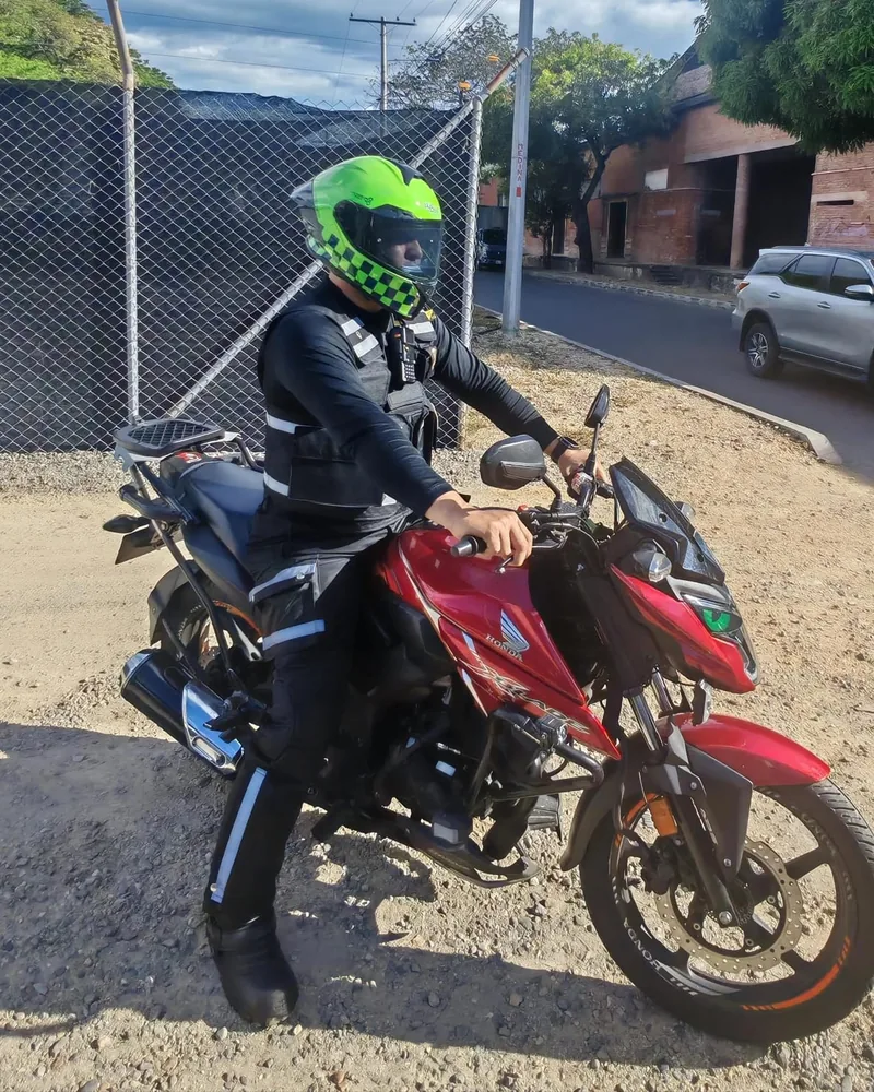 Mensajero de GRM junto a su moto roja en Girardot